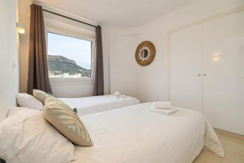 two beds in a room with a window at La Perla vista al mar Fabiola 1 in Calpe