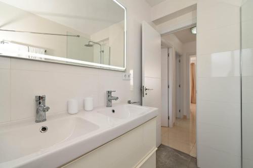 a white bathroom with a sink and a mirror at La Perla vista al mar Fabiola 1 in Calpe