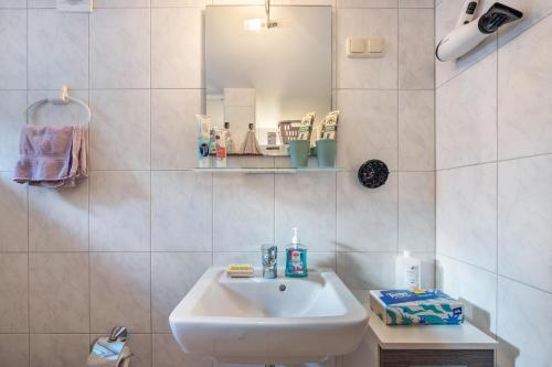 a bathroom with a white sink and a mirror at Modernes Apartment am Deister in Springe