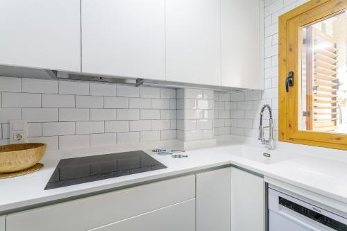 a white kitchen with a sink and a window at Los Arenales al Sol in Arenales del Sol