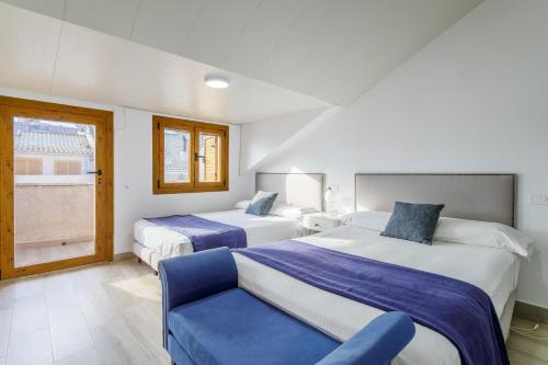 a hotel room with two beds and a chair at Los Arenales al Sol in Arenales del Sol