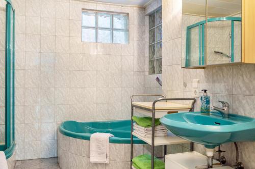 a bathroom with a blue sink and a tub at Ferienwohnung Brenda in Schillingsfürst