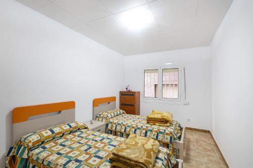 two beds in a room with white walls at Casa Menvil in Sant Jordi de Cercs