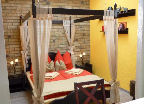 a bedroom with a canopy bed with red pillows at Ferienwohnung Hasi 2 am Kurpark in Bad Frankenhausen