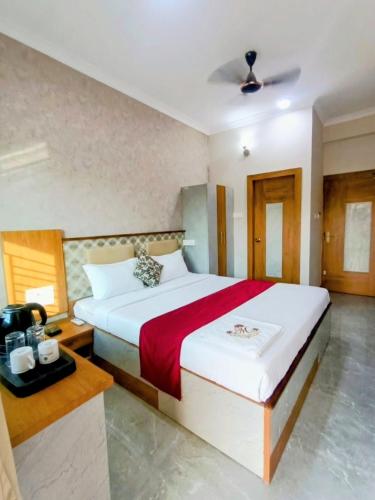 a bedroom with a large bed with a red blanket at Baibhab Convention & Resort in Bhubaneshwar