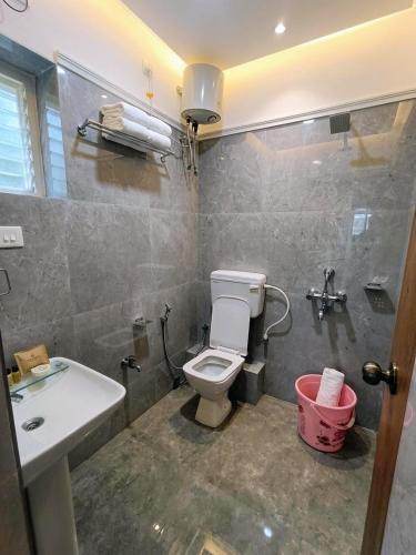 a bathroom with a toilet and a sink at Baibhab Convention & Resort in Bhubaneshwar