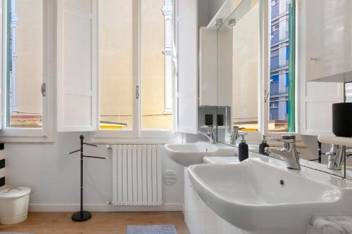a bathroom with three sinks and two mirrors at La Casa Del Marinaio in Rapallo