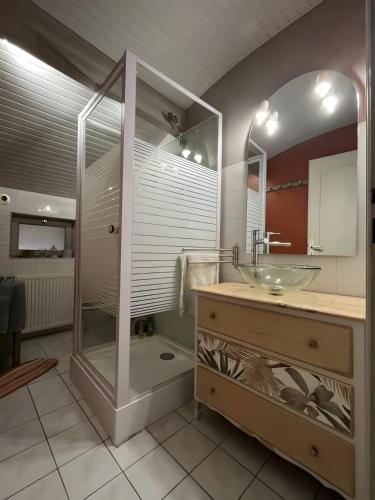 a bathroom with a glass sink and a shower at Chambre d'hôte Léontine in Lamagistère