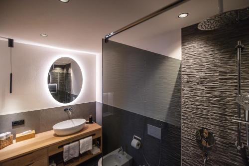 a bathroom with a sink and a glass shower at Rueper Hof Chalet Ruipa in Valdaora