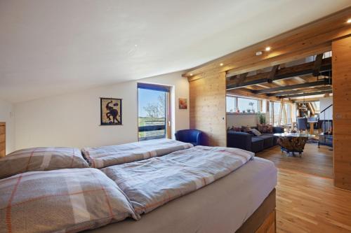 a large bed in a bedroom with a living room at I'd Love To Be Home in Bidingen