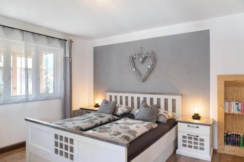a bedroom with a bed with a heart decoration on the wall at Andis Ferienwohnung in Farchant