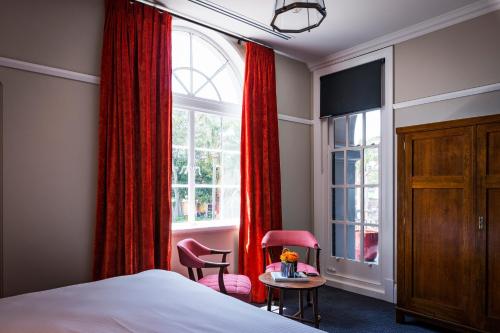 a bedroom with a bed and a window with red curtains at The North Sydney Hotel in Sydney