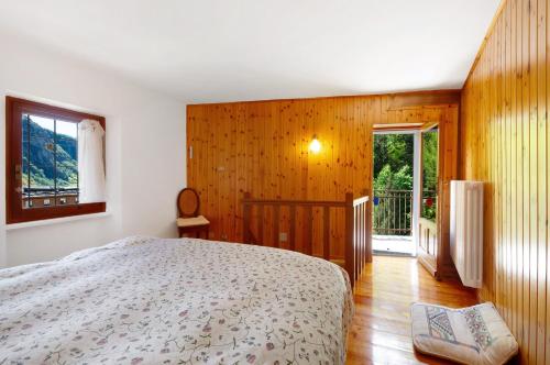 a bedroom with a bed and a wooden wall at Casa Savin 35 in Pontboset