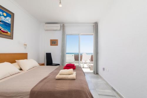 a bedroom with a bed with towels on it at Superb Large Apartment on the Beach in Marbella