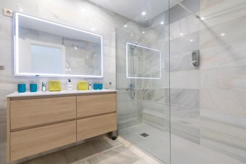 a bathroom with a shower with a sink and a mirror at Superb Large Apartment on the Beach in Marbella