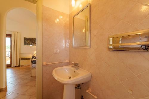 a bathroom with a sink and a mirror at Casa Vacanze Fragola in Olbia