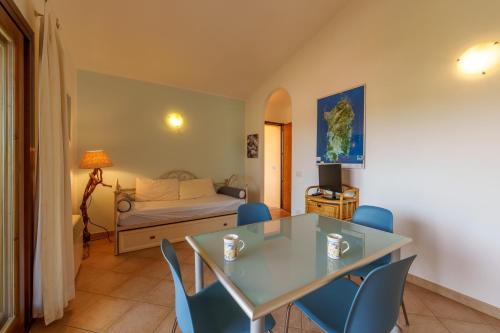 a living room with a table and chairs and a bed at Casa Vacanze Fragola in Olbia