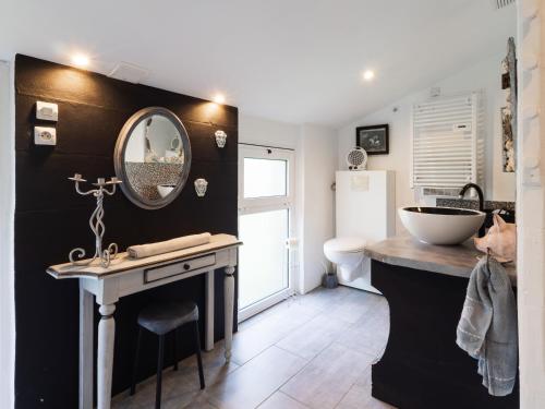 a bathroom with a sink and a mirror at Gite Atelier La Croix Blanche in Kermaria-Sulard