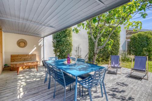 a patio with a blue table and chairs and a piano at Maison Côté Bassin in Arcachon