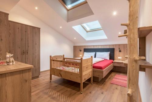 a bedroom with a crib and a bunk bed at Balbeinhof Apt Reh in Luson