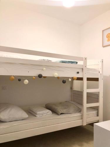a bunk bed in a room with two bunk beds at Le studio d'Apoline avec piscine in La Tranche-sur-Mer