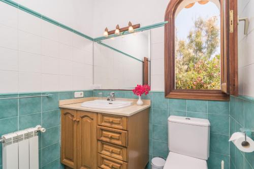 a bathroom with a sink and a toilet and a mirror at Villa Solymar in Cala Serena