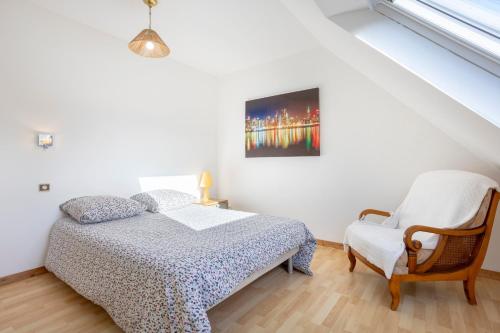 a bedroom with a bed and a chair at Ty Bénodet - Maison de vacances in Bénodet