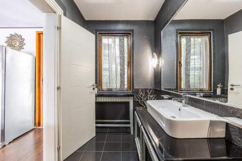 a bathroom with a sink and a mirror at Tranquility Villa with Pool Private Garden & BBQ by PikHost in Tirana
