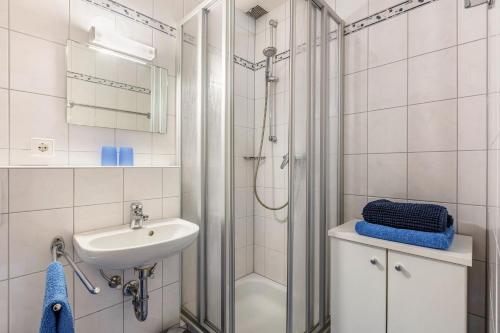 a white bathroom with a shower and a sink at Wohnung Claudia mit Balkon in Todtnau