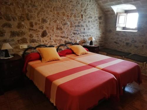 two beds in a room with brick walls at Mas Pareta - La Parra in Fonolleras