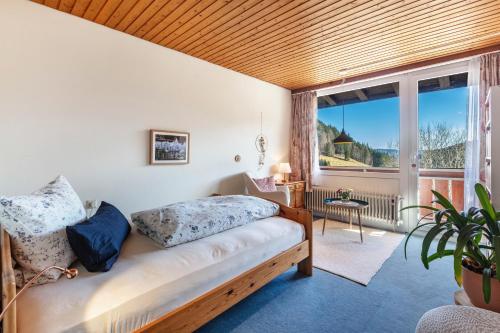 a bedroom with a bed and a large window at Wohnung Claudia mit Balkon in Todtnau