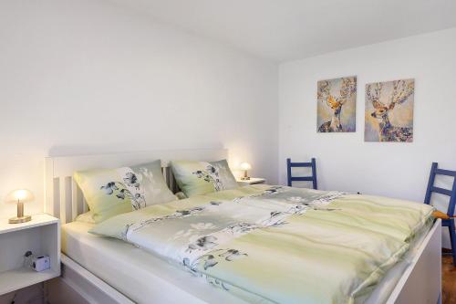 a white bed with blue and white sheets and pillows at Haus am Buck in Müllheim