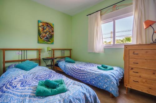 a bedroom with two beds and a dresser and a window at Mediterranean Vacation in Mallorca in Cala Pi