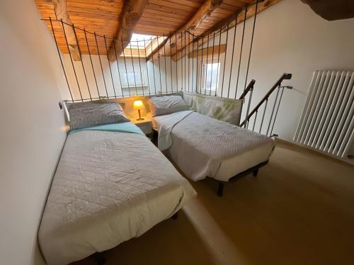 a bedroom with two beds and a lamp on a table at Alpi Liguri - Villa Giulia in Peveragno