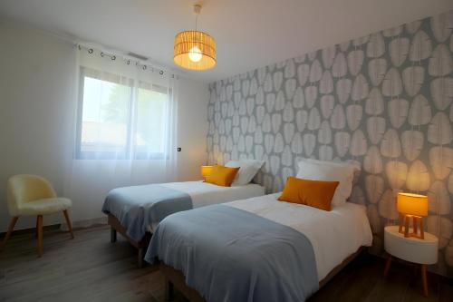 a bedroom with two beds and a window at Gîte Basmatho in Yvrac