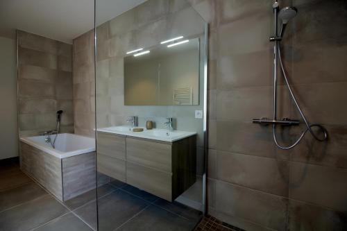 a bathroom with a shower and a sink and a mirror at Gîte Basmatho in Yvrac