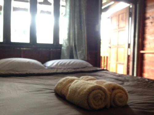 a bed with two towels on top of it at JJ at Chiangkhan in Chiang Khan