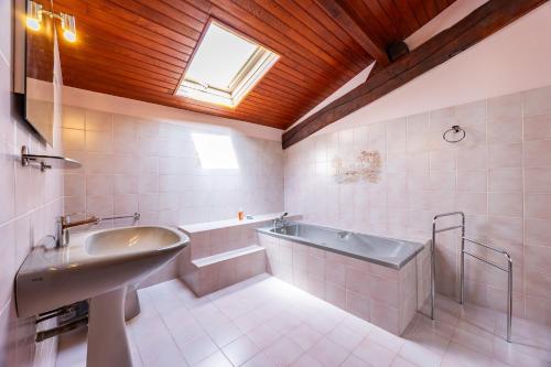 a bathroom with a bath tub and a sink at La Maison de Piquereau in Sauveterre-de-Guyenne