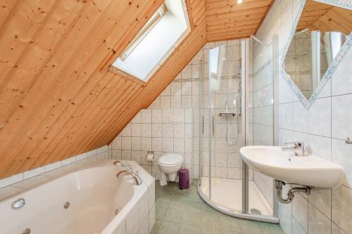 a bathroom with a tub and a sink and a toilet at Ferienwohnung Fisch in Loddin