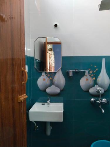 a bathroom with a sink and vases on the wall at CloudGuestHouse in Kottakupam