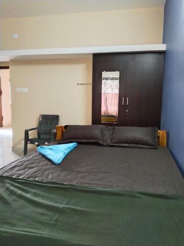 a large bed in a room with a chair at CloudGuestHouse in Kottakupam
