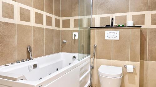 a bathroom with a white tub and a toilet at 1 Bedroom Apartment at Centaurus Mall in Islamabad