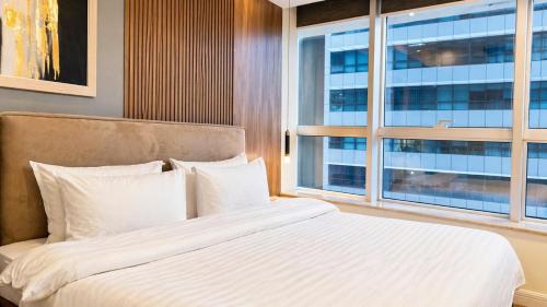 a bedroom with a large bed and a window at 1 Bedroom Apartment at Centaurus Mall in Islamabad
