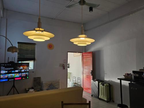 a living room with three lights hanging from the ceiling at Dramatic Exit Bangkok - Cozy Loft House near Suvarnabhumi Airport in Bangkok