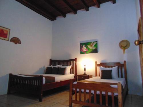 a bedroom with two beds and a lamp in it at Hotel El Maltese in Granada