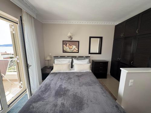 a bedroom with a large bed and a large window at Maisonettes Athina in Chrysi Ammoudia