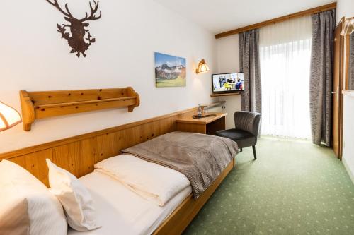 a hotel room with a bed and a desk at Hotel Liberia in Oberstdorf