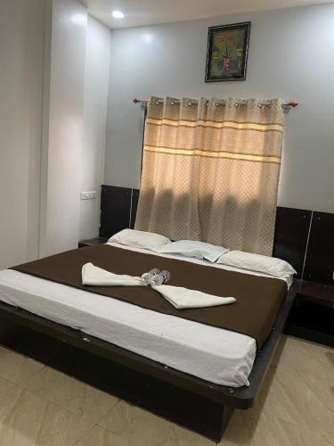 a large bed in a room with a window at Bbhakt niwas in Tuljapur