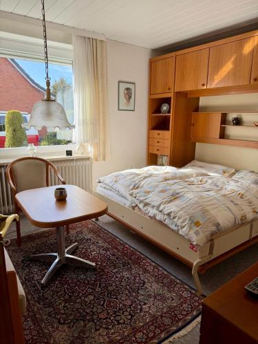 a bedroom with a bed and a table and a chair at Südblick 1 in Fehmarn
