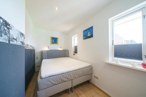 a small bedroom with a bed and a window at Ferienpark Achtern Diek Ferienhaus Malmö in Otterndorf